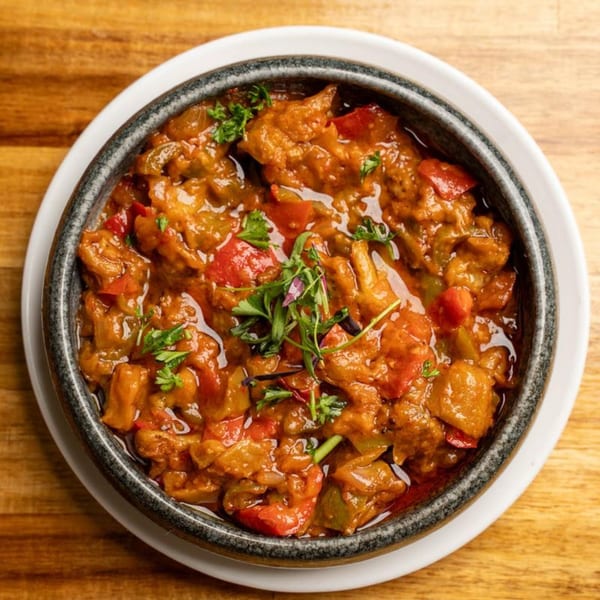 A close-up of a Mediterranean stew with vegetables and meat, garnished with fresh herbs.