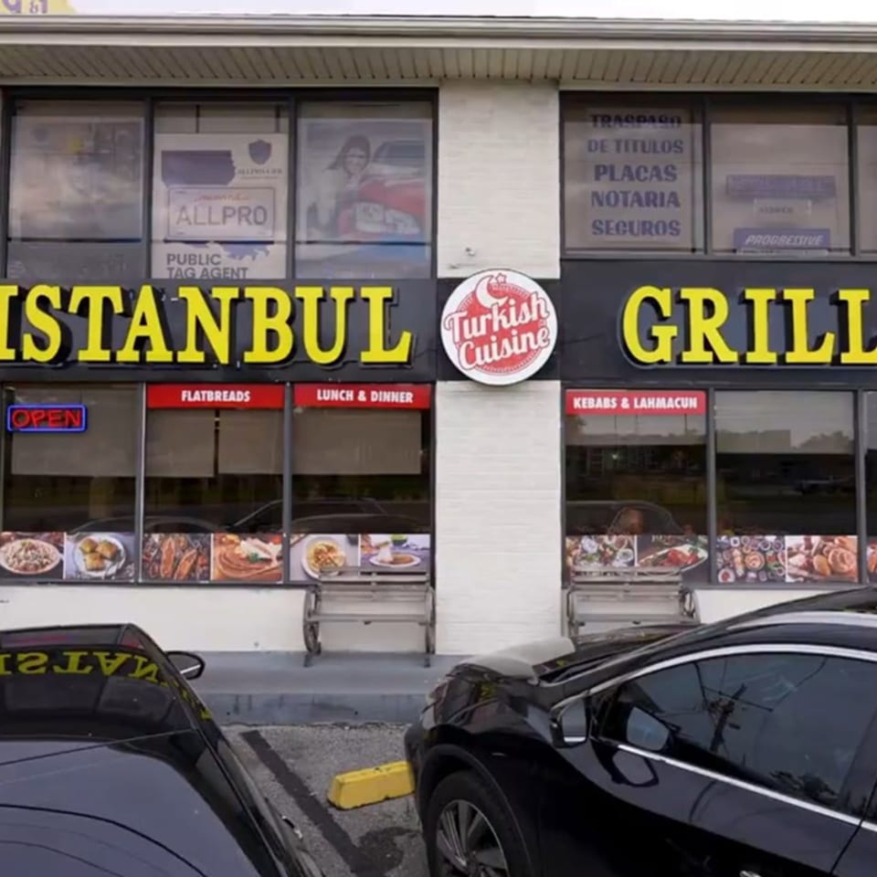 Exterior of ISTANBUL GRILL METAIRIE, a Mediterranean restaurant, with its yellow sign and food displays.